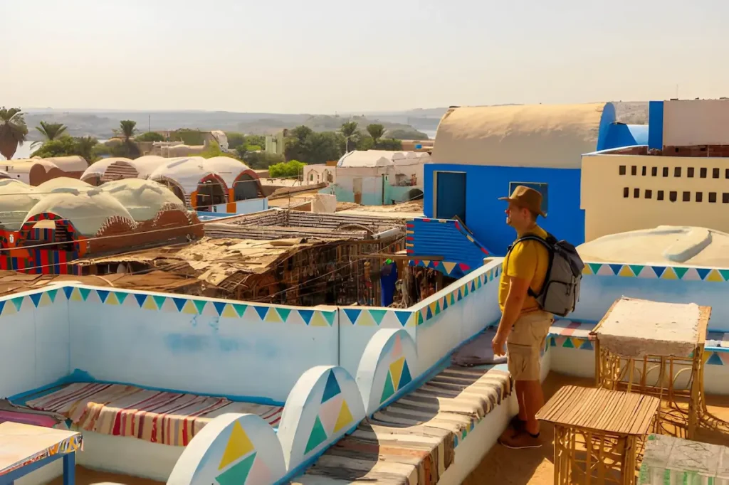 Man in profile looking out over the landscape in the middle of Nubian village houses in Egypt Nile River Cruises Guide