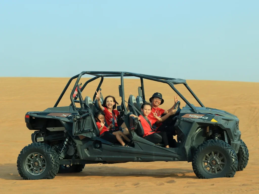 Dubai, Dubai, United Arab Emirates Smiling Family Riding Buggy on Desert