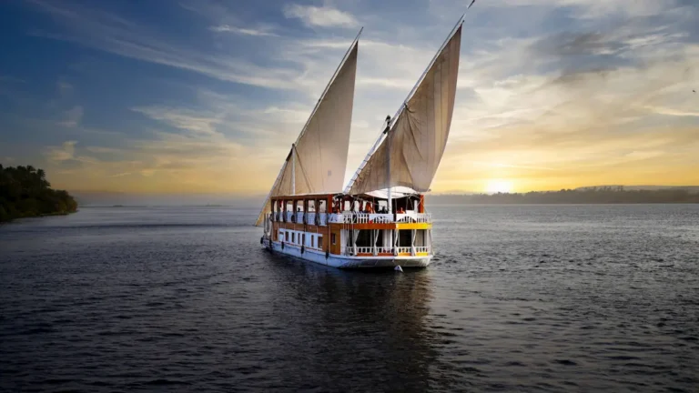 Amoura Dahabiya sailing on the Nile with two sails at sunset