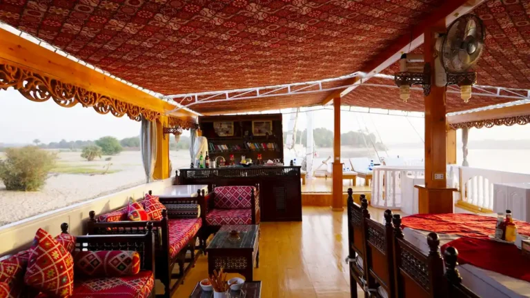 Covered lounge and dining area aboard Amoura Dahabiya overlooking the Nile