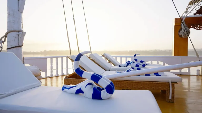 Cushioned sunbeds and folded towels on the Amoura Dahabiya sun deck
