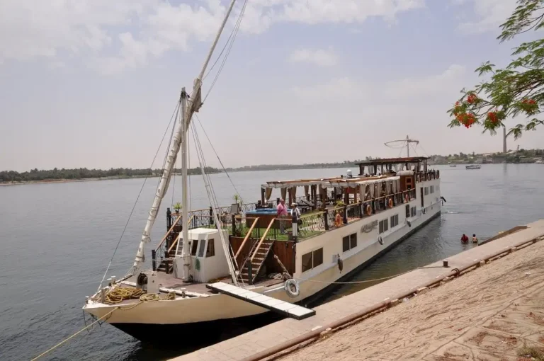 Merit I Dahabiya moored on the Nile with its outdoor sun deck and sailing rigging