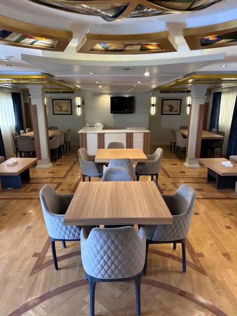Merit I Dahabiya indoor restaurant with wooden tables and upholstered chairs