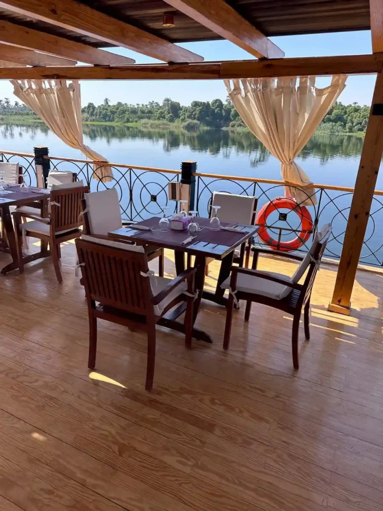 Shaded outdoor dining area on the Merit I Dahabiya sun deck overlooking the Nile