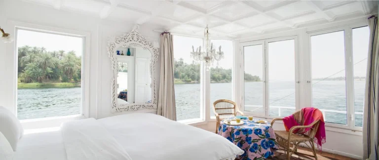 Panoramic Dahabiya cabin with a double bed and private seating area