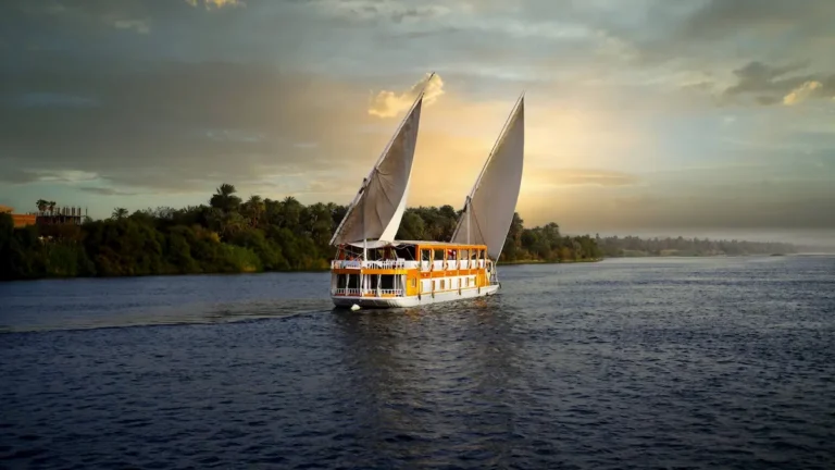 Amoura Dahabiya cruising under sail on the Nile during sunset