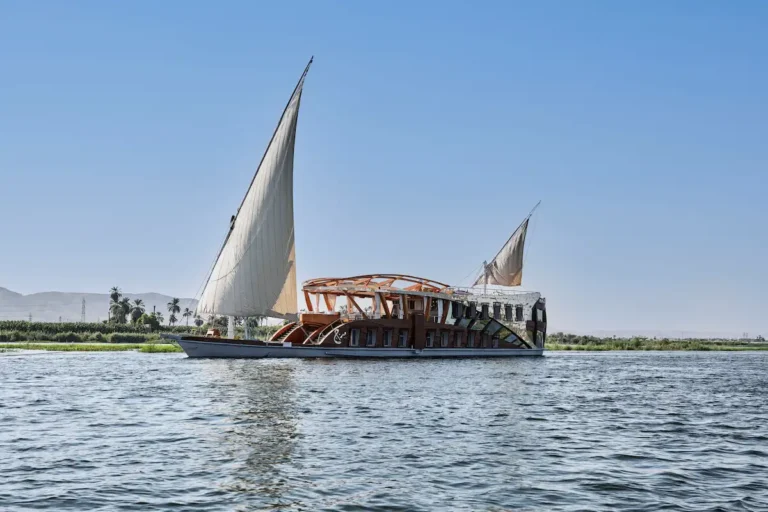 Side view of Mazaj Seba Dahabiya sailing through Upper Egypt
